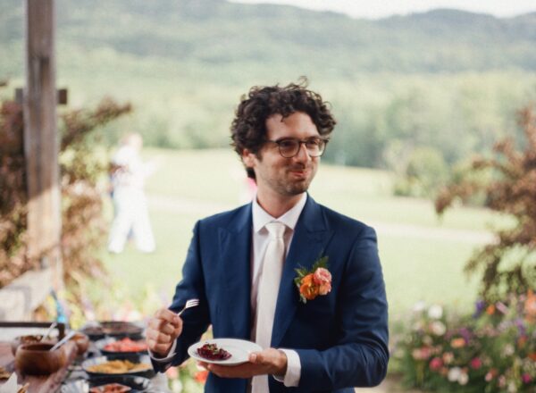 A groom enjoying some appetizers. Photo by Hayes and Baker.
